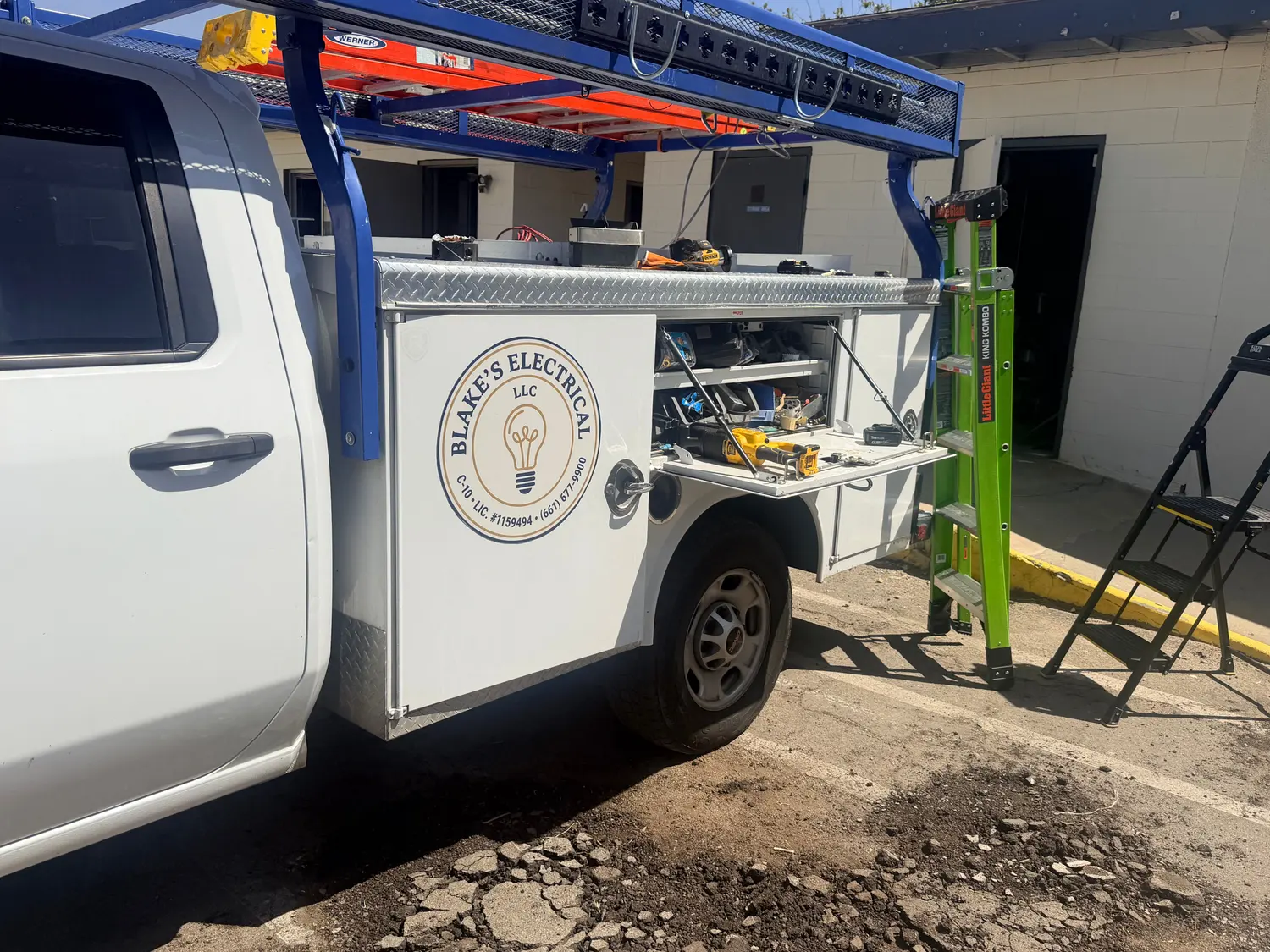 A Blake's Electrical service truck parked at a job site in Bakersfield, conduit runs on the wall behind it.