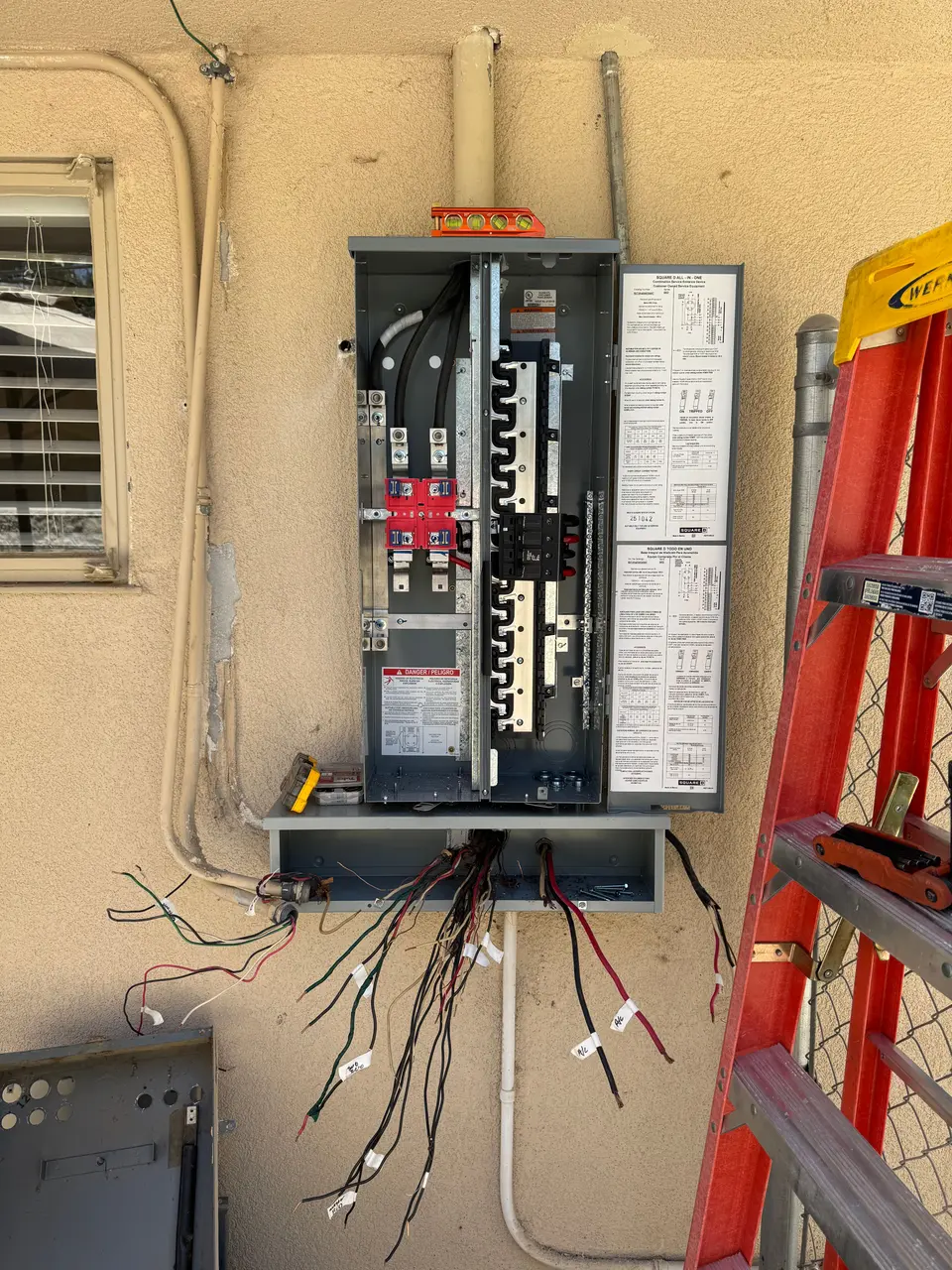 A residential 200 amp service panel being replaced on a Bakersfield home, the dead front off and the branch circuits labeled and ready to land.