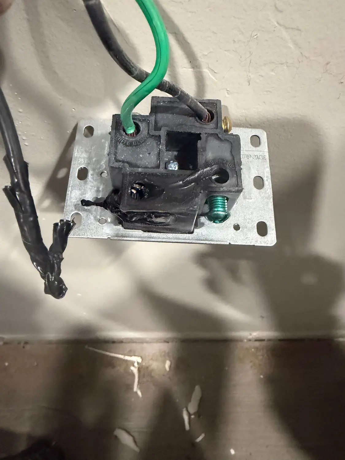 A burned-out receptacle removed during an electrical repair in Bakersfield, its contacts charred from overheating behind the wall.