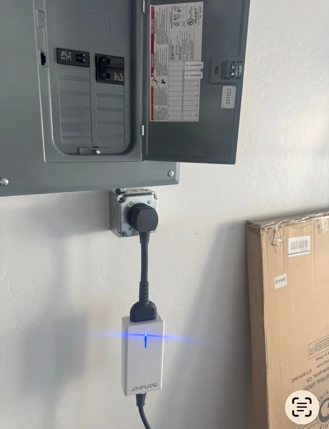 A residential panel with a dedicated double-pole EV-charger breaker and an updated 'EV CHARGER' directory entry, feeding a load-management module mounted below.