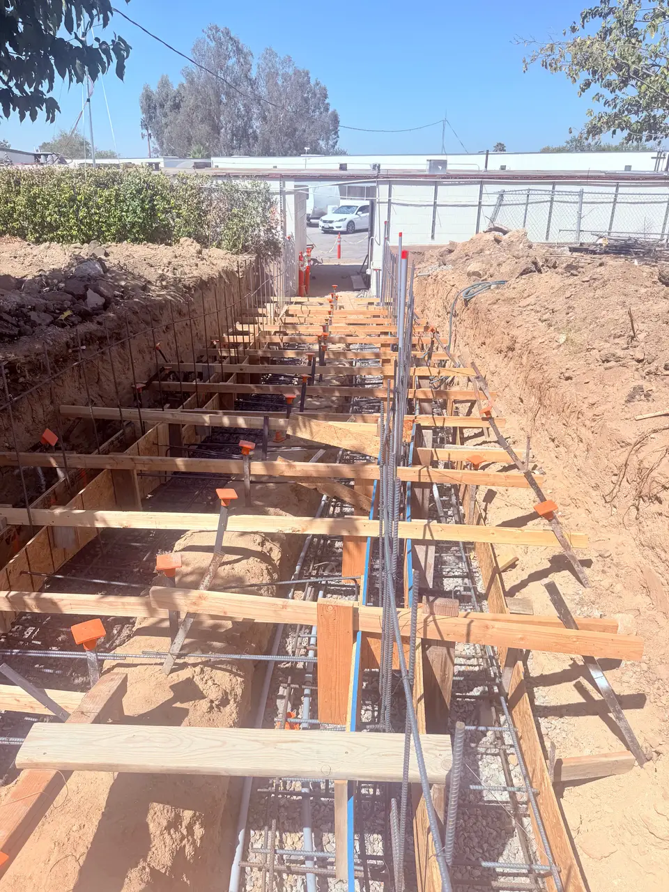 Electrical conduit run and tied off through formed footings before the concrete pour on a Kern County site.